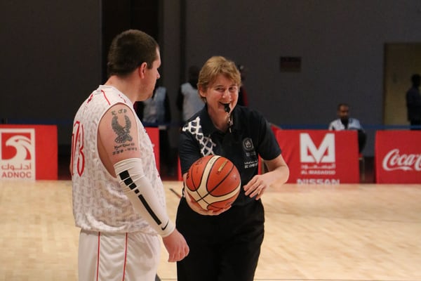 Athlete and official talking on the basketball court